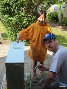 Katrine helped to paint the finishing touch for her new room out front with her Baba.