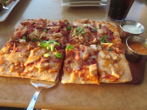 GF flatbread with sauce, chicken, bacon and cheese.